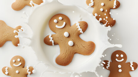 牛奶中的微笑姜饼人圣诞节甜品摄影图