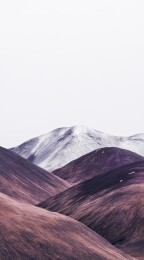 雪山与红土丘陵的自然景观