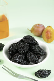 白盘里的西梅干与新鲜西梅