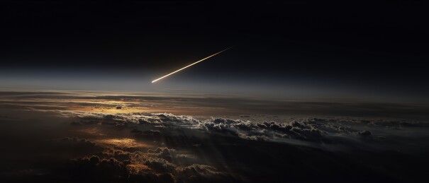 一颗炽热的陨石从黑暗天空高速坠向地球