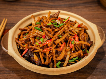 陶制砂锅中的干萝卜条炒肉