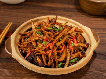 陶制砂锅中的干萝卜条炒肉