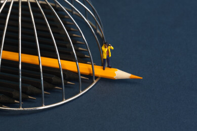 站在突破牢笼黄色铅笔上的男士微缩创意