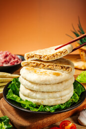 筷子夹起黑盘里堆叠馅饼的内馅