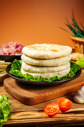 木板上的黑盘装着堆叠的馅饼