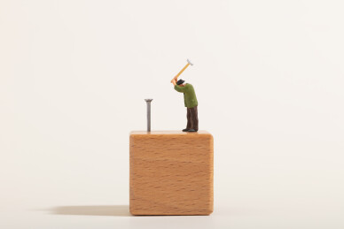 微缩创意木工小人拿着锤子向木头里钉钉子