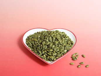 红色桌面上的一盘子坚果年货南瓜子南瓜仁