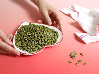 红色桌面上的一盘子坚果年货南瓜子南瓜仁