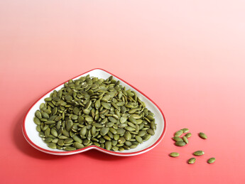 红色桌面上的一盘子坚果年货南瓜子南瓜仁