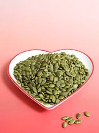 红色桌面上的一盘子坚果年货南瓜子南瓜仁