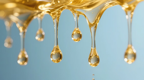 金色蜂蜜滴落浅蓝背景
