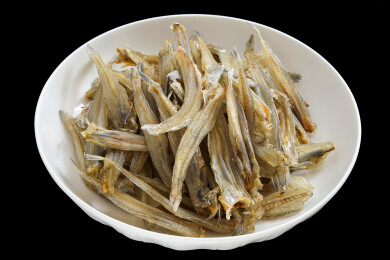 黑色背景上的一盘子海鲜海味干货小鱼干