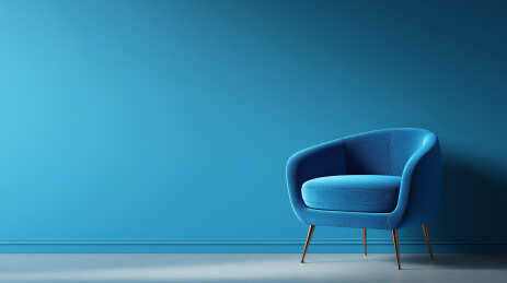 蓝墙灰地旁的蓝色单人沙发椅