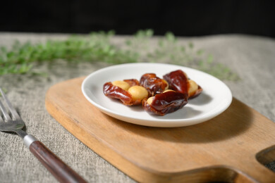 桌面上的盘子里的美味可口的椰枣夏威夷果仁