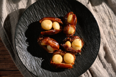 桌面上的盘子里的美味可口的椰枣夏威夷果仁