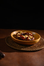 桌面上的盘子里的美味可口的椰枣夏威夷果仁