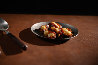 桌面上的盘子里的美味可口的椰枣夏威夷果仁