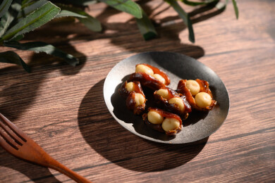 桌面上的盘子里的美味可口的椰枣夏威夷果仁