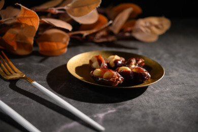 桌面上的盘子里的美味可口的椰枣夏威夷果仁