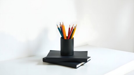 阳光桌面文具笔筒和书本静物场景