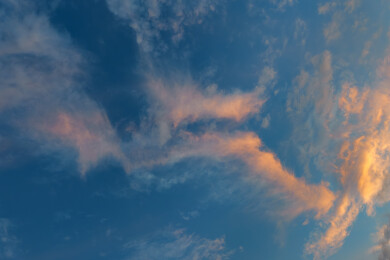 蓝色天空中美丽的橙红色羽毛状卷云