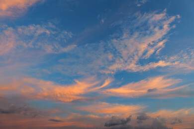 蓝色天空中美丽的橙红色羽毛状卷云