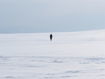 广袤的冰天雪地里的孤独行走的人