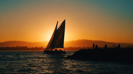 海边日落时的帆船剪影