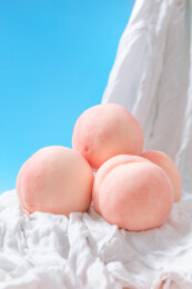 粉嫩水蜜桃堆叠于白布上