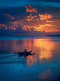 日落海面独舟剪影