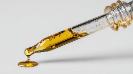 滴管中的金色液体缓缓滴落