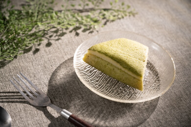 桌面上的盘子里的美味可口的抹茶蛋糕卷