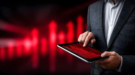 商务人士手持平板查看红色数据图表