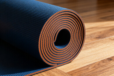 蓝色瑜伽垫卷放木地板