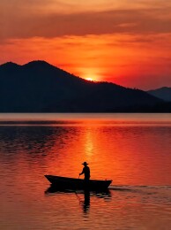 丹霞落日下的渔舟