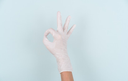 戴着白色一次性手套的手做OK手势