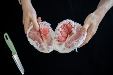 双手持剥开的红心柚及刀具