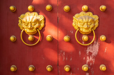 红色木质大门和成一排的黄的门钉