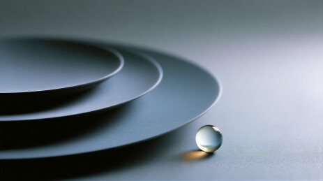 叠放的深色盘子与透明球体