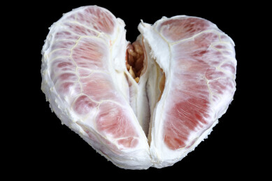 黑色背景上一个剥开的中秋节美食水果红柚子