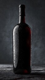 深色酒瓶静置暗影