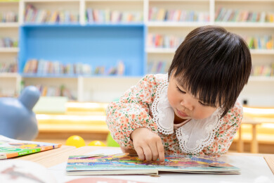 一名中国小女孩在图书馆绘本区阅读