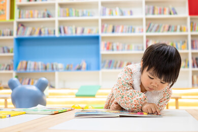 一名中国小女孩在图书馆绘本区阅读