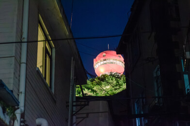 小巷间远望青岛信号山红色球形建筑夜景