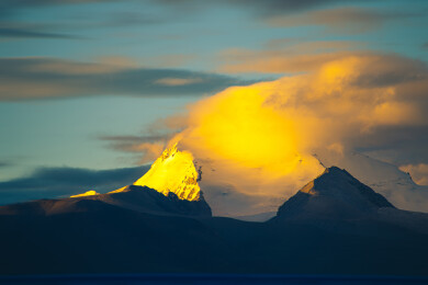 中国西藏卓木玉莫旗云下的日照金山