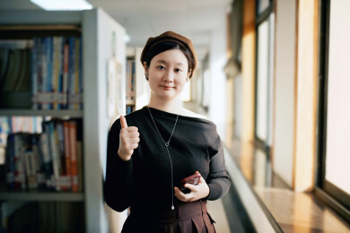 在图书馆里竖起大拇指的女人