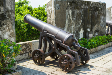 澳门城市风光墙边有一堵石墙上放着一门大