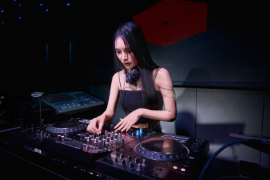 穿着性感黑色吊带裙的女DJ在打碟