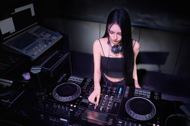 穿着性感黑色吊带裙的女DJ在打碟