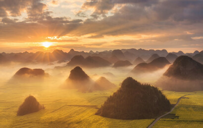 中国云南罗平峰林金鸡峰丛油菜花日出航拍图